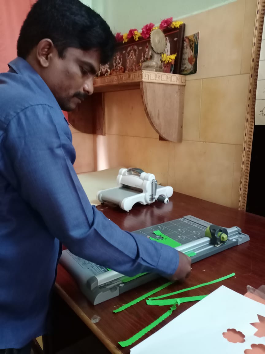 A man at the handicrafts workshop using the paper cutter